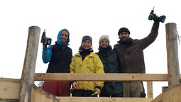 Vier Personen stehen auf einer Fanganlage und halten Werkzeuge in den Händen