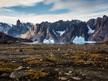 Mit Schnee bedeckte Berge erheben sich aus karger Landschaft