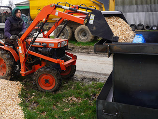 Mit Hilfe eines Traktors wird die Biomasse in die Anlage gefüllt.