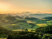 Panoramablick über ein Tal mit naturbelassenen Wäldern sowie Kulturlandschaft