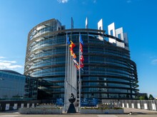 Europäisches Parlament mit Flaggen in Sonnenschein