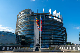 Europäisches Parlament mit Flaggen in Sonnenschein