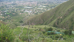 Blick von den grün bewachsenen Anden ins bewohnte Tal von Cochabamba