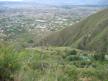 Blick von den grün bewachsenen Anden ins bewohnte Tal von Cochabamba