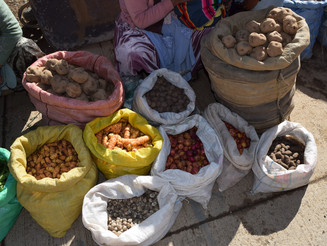Kartoffeln und andere Nahrungsmittel stehen in Säcken auf Boden