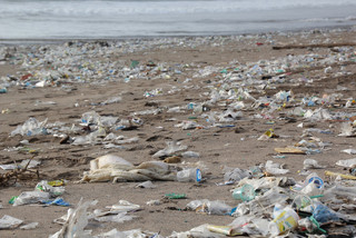 Plastikmüll liegt an Sandstrand