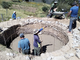 Boden eines Wasserbeckens wird von mehreren Männern mit Beton ausgegossen.