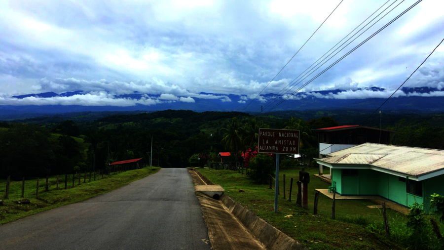 Straße in Dorf in Costa Rica vor dem Hintergrund dicht mit Wald bewachsener Berge