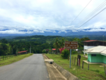 Straße in Dorf in Costa Rica vor dem Hintergrund dicht mit Wald bewachsener Berge