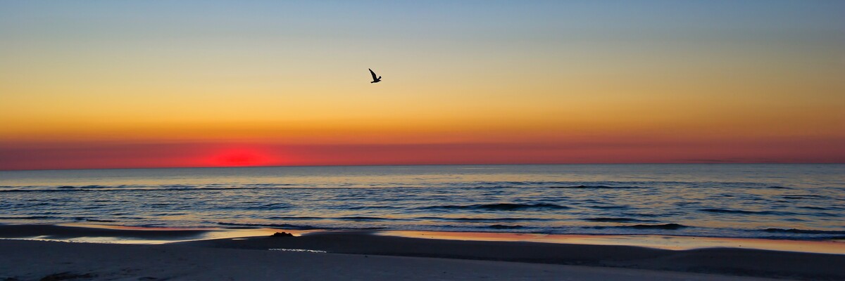 Rot, gelb, blauer Sonnenuntergang über dem Meer