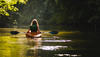 Frau fährt Kanu auf einem Fluss