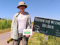 Frau hält Schild der Deutschen Postcode Lotterie in der Hand