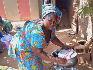 Frau aus Malawi kocht auf einem Holzkohle Kocher