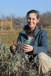 Katja Wiese, die Geschäftsführerin von Naturefund, schneidet Pflanzen in einem Beet