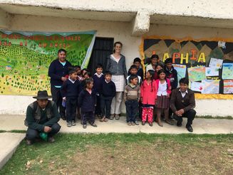 Kinder und Lehrerinnen stehen vor einer Schule in Bolivien