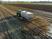 Gülle wird von Traktor auf Acker ausgebracht