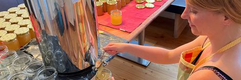 Frau füllt Honig in ein Glas ab